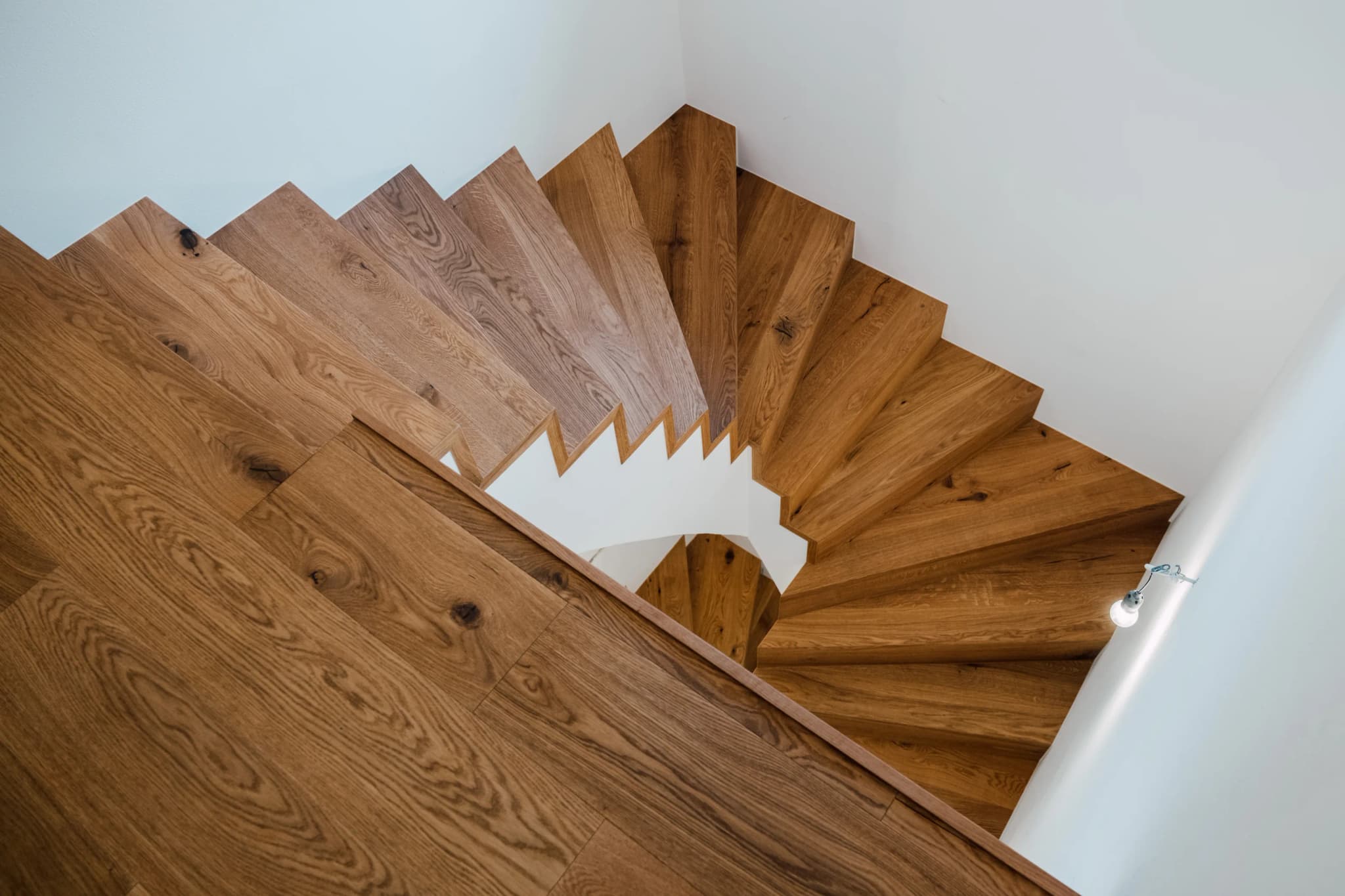 Wendeltreppe aus Eiche von oben mit geometrischem Stufenmuster in Braunau