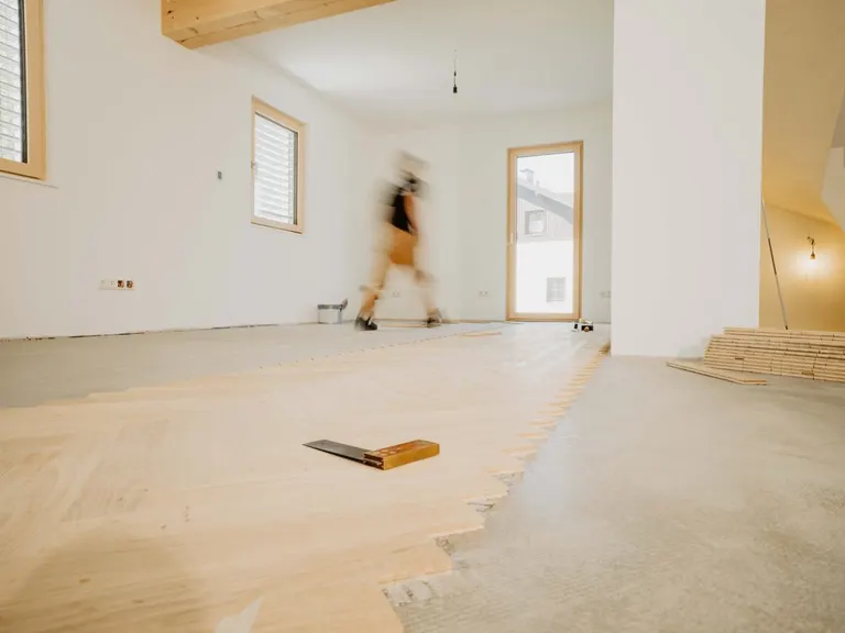 Baustelle mit teilweise verlegtem Boden und Werkzeug