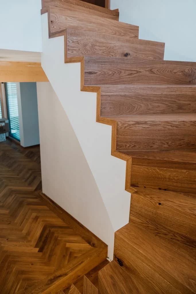 Holztreppe aus Eiche mit Schattenwurf auf Fischgrätboden