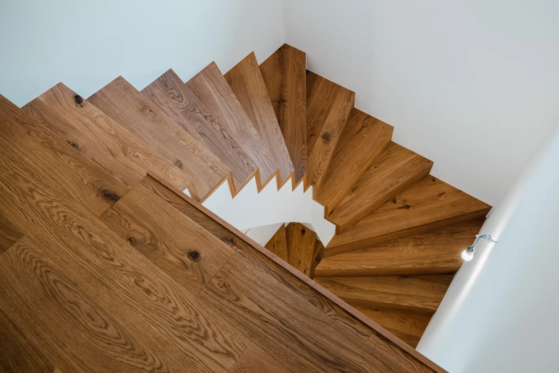 Wendeltreppe aus Eiche von oben mit geometrischem Stufenmuster in Braunau
